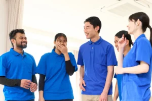 介護施設で外国人スタッフと日本人職員が笑顔で会話している様子