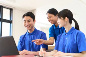 介護施設で外国人スタッフと日本人職員が笑顔で会話している様子