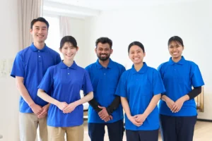 介護施設で笑顔で働く外国人スタッフと日本人職員の様子