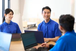 介護施設で働く外国人スタッフと日本人職員が笑顔で話す様子