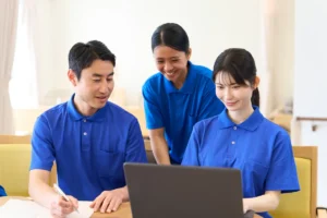 介護施設で外国人スタッフと日本人職員が笑顔で会話している様子