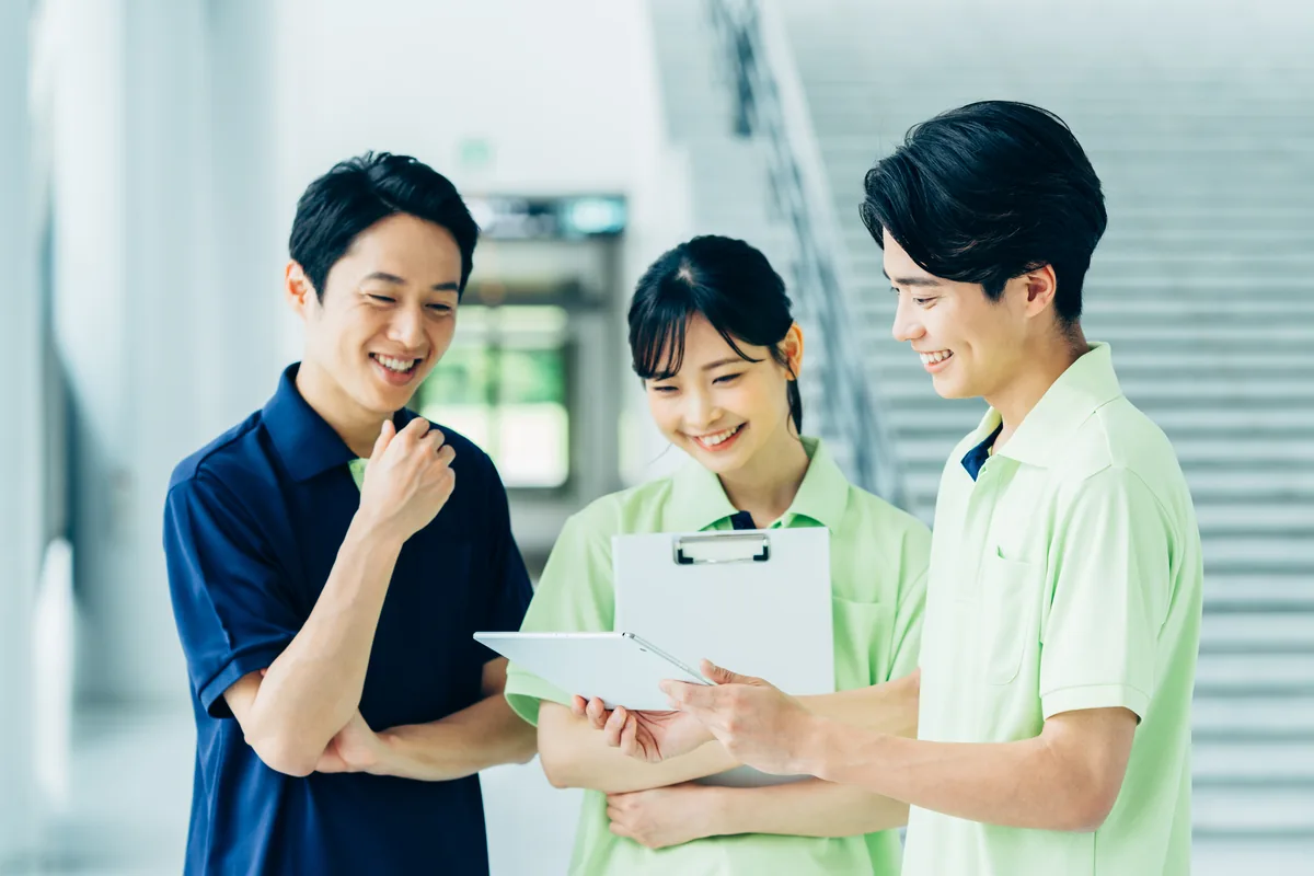 介護施設の職員が複数人で書類を見ながら話し合っている様子