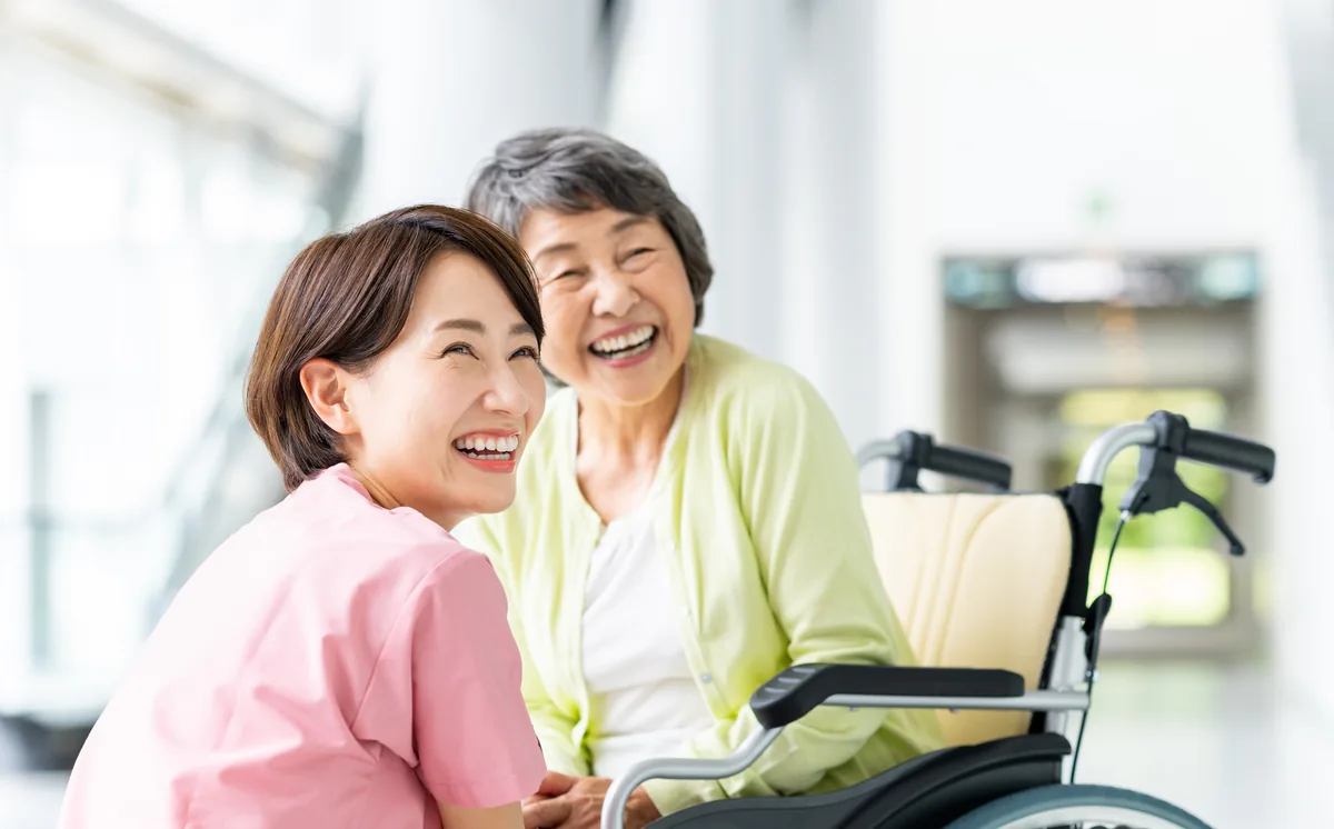 介護施設で笑顔を見せる女性スタッフと利用者の様子