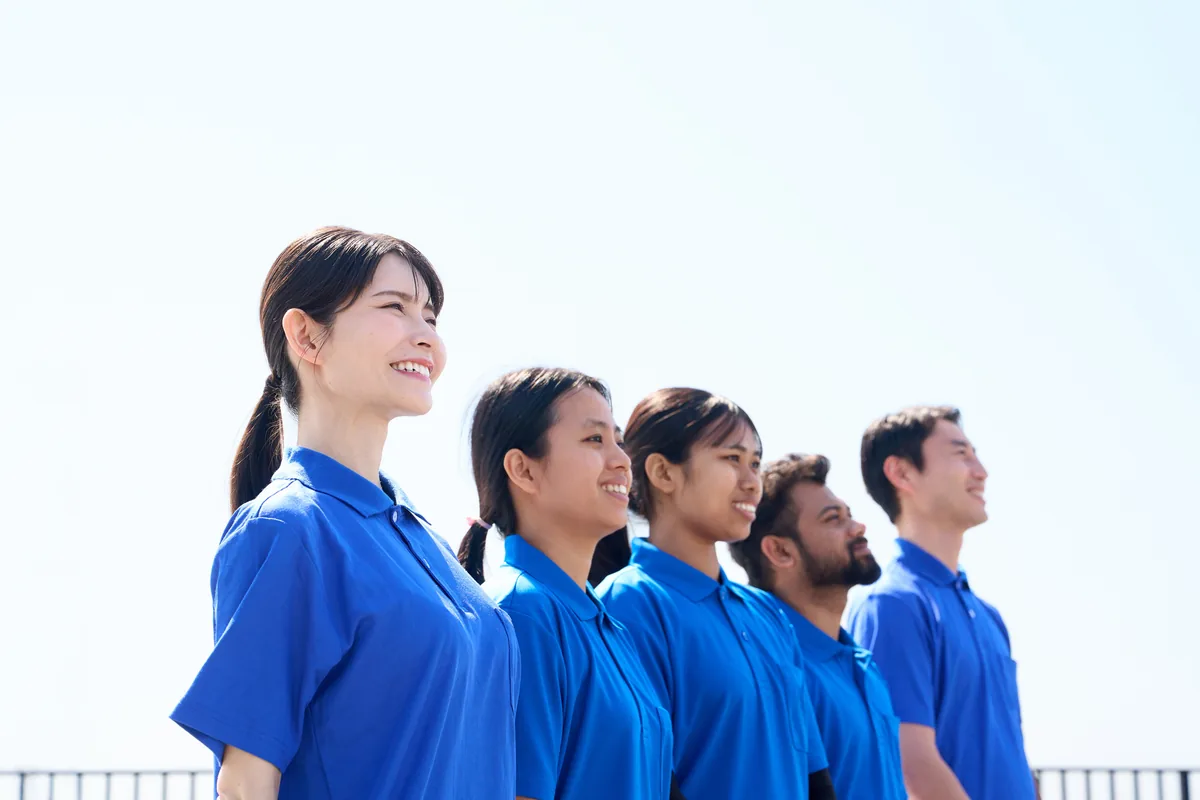 介護施設で笑顔を見せる外国人スタッフと日本人職員