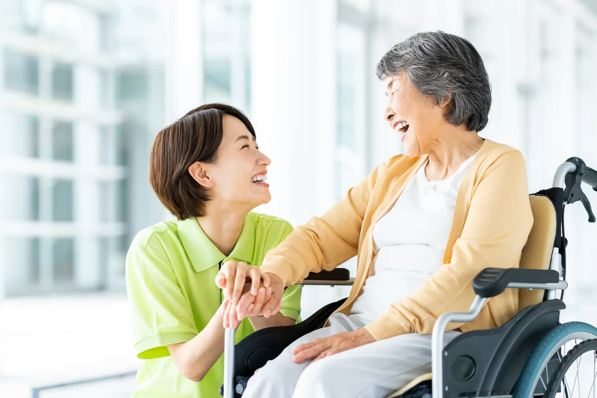 介護施設で利用者と職員が笑顔で会話をしている様子