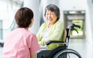 介護施設で高齢者と職員が笑顔で会話をしている様子