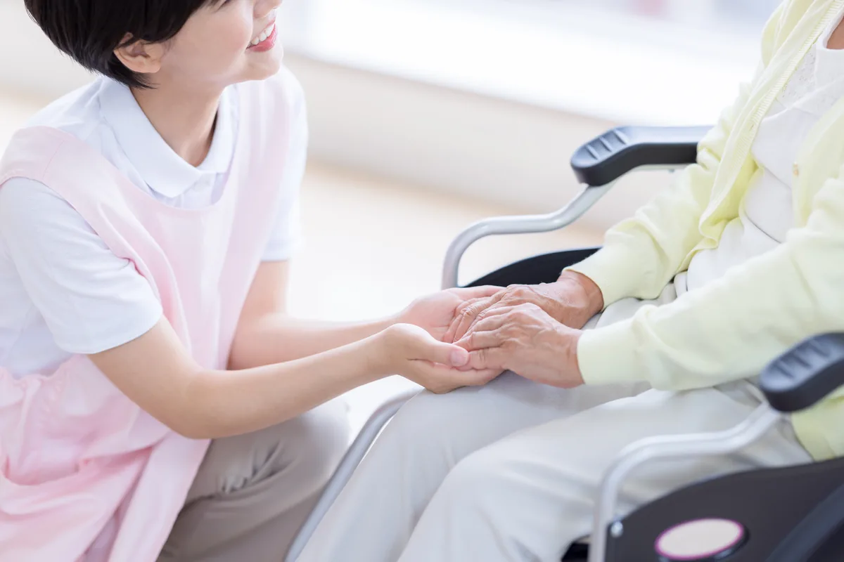 デイサービスの職員が利用者に寄り添い笑顔で対応している様子
