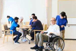 介護施設で笑顔で働く外国人スタッフと日本人職員の様子